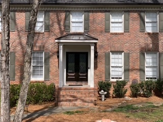 Black double doors on brick home — Westbrook Roofing and Remodeling