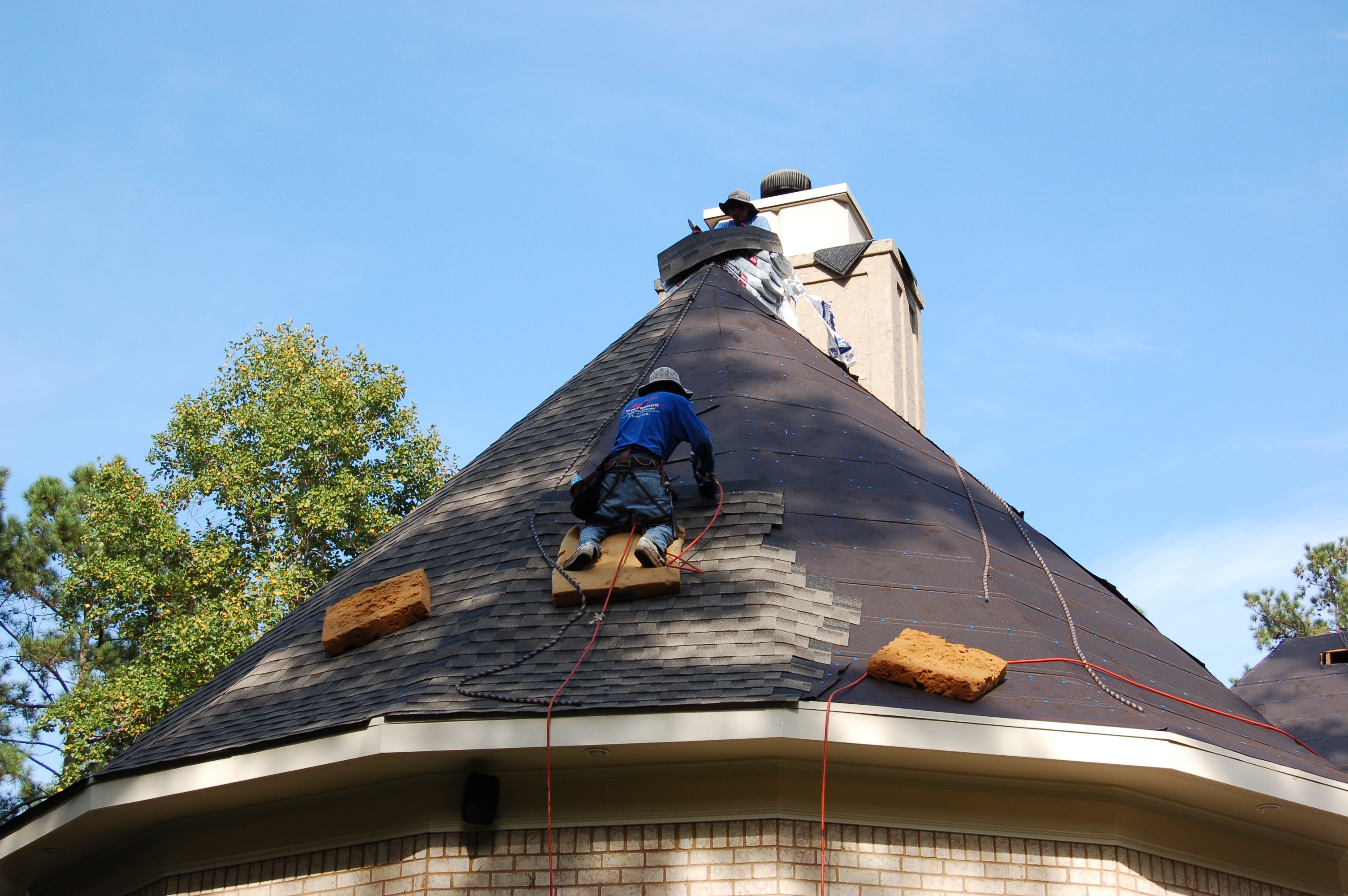Westbrook crew installing shingles on a steep turret roof