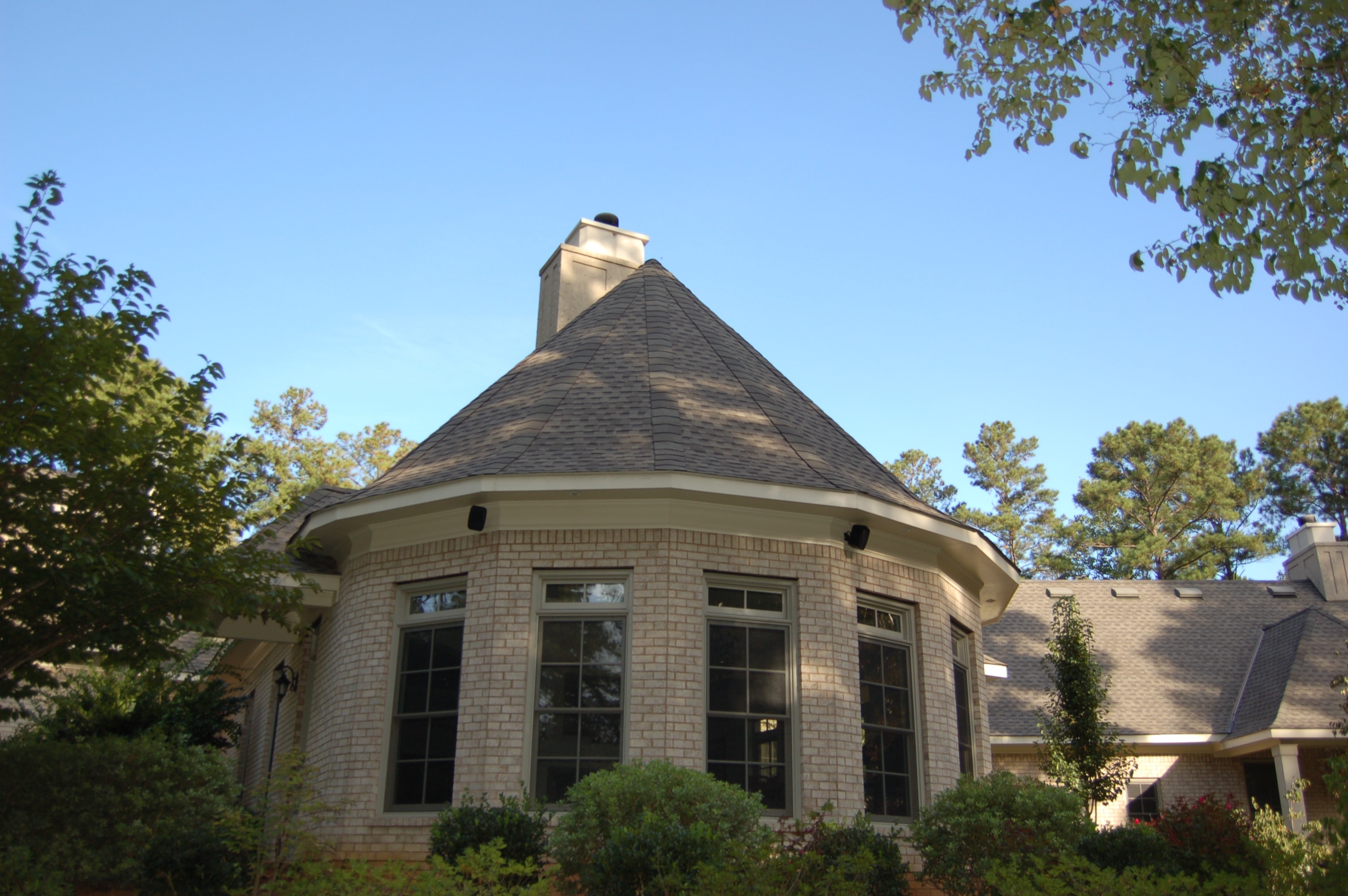Completed turret roof installation on a brick home