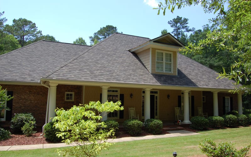 Professional roofer installing shingles on residential roof
