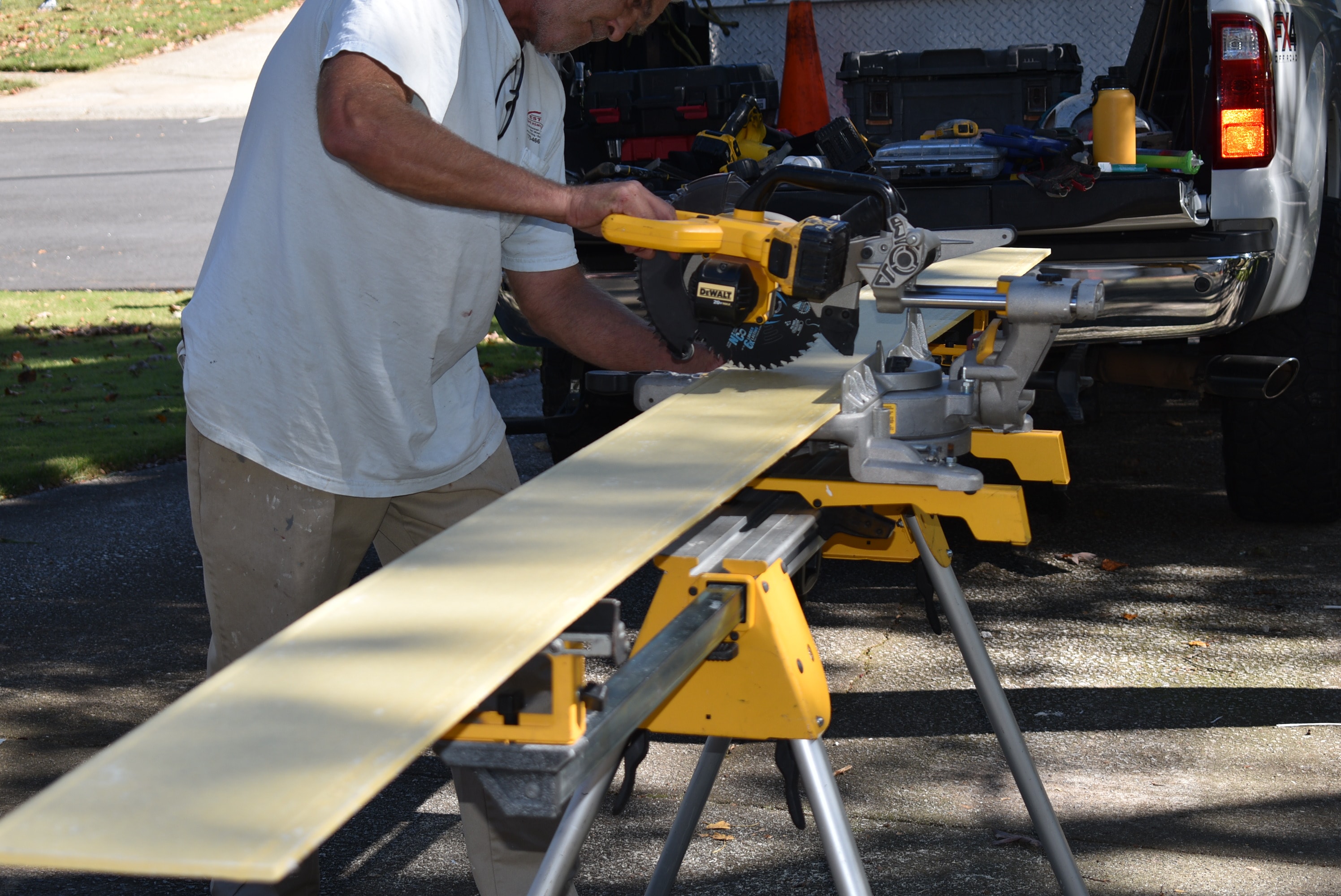 Todd Westbrook cutting fascia board on a miter saw at a job site