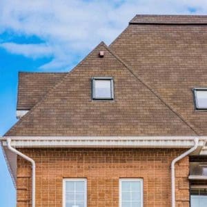 A brown brick house with white trim and windows.