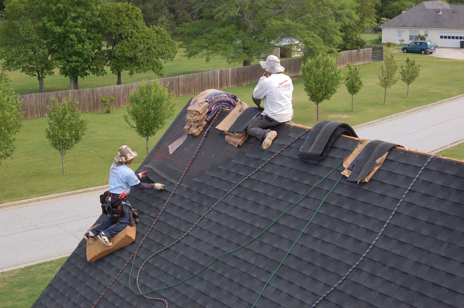 A group of people working on the roof of a house.