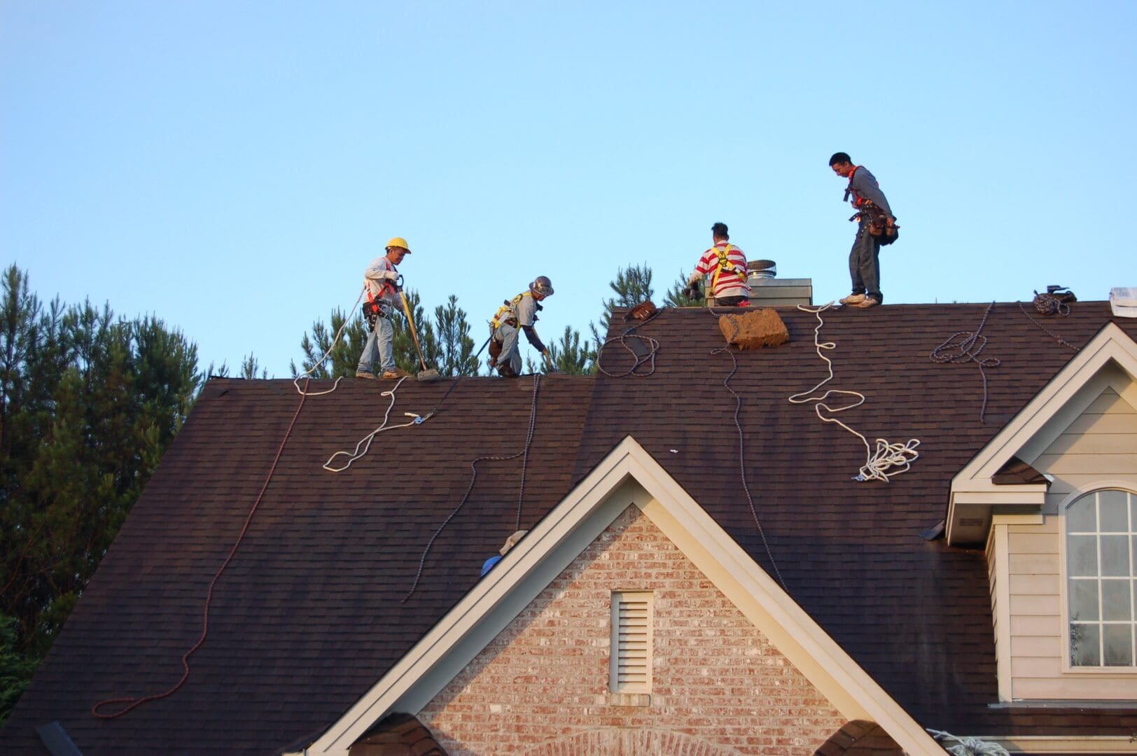 A group of men working on the roof of a house.