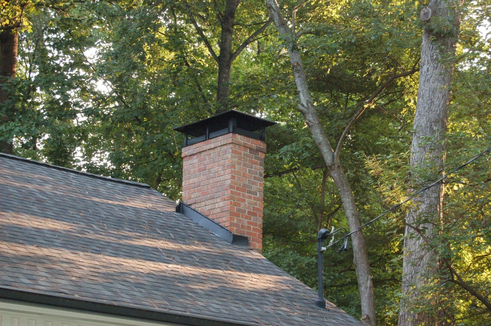 A brick chimney on the side of a house.