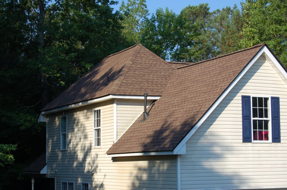 A house with brown shingles and white trim.