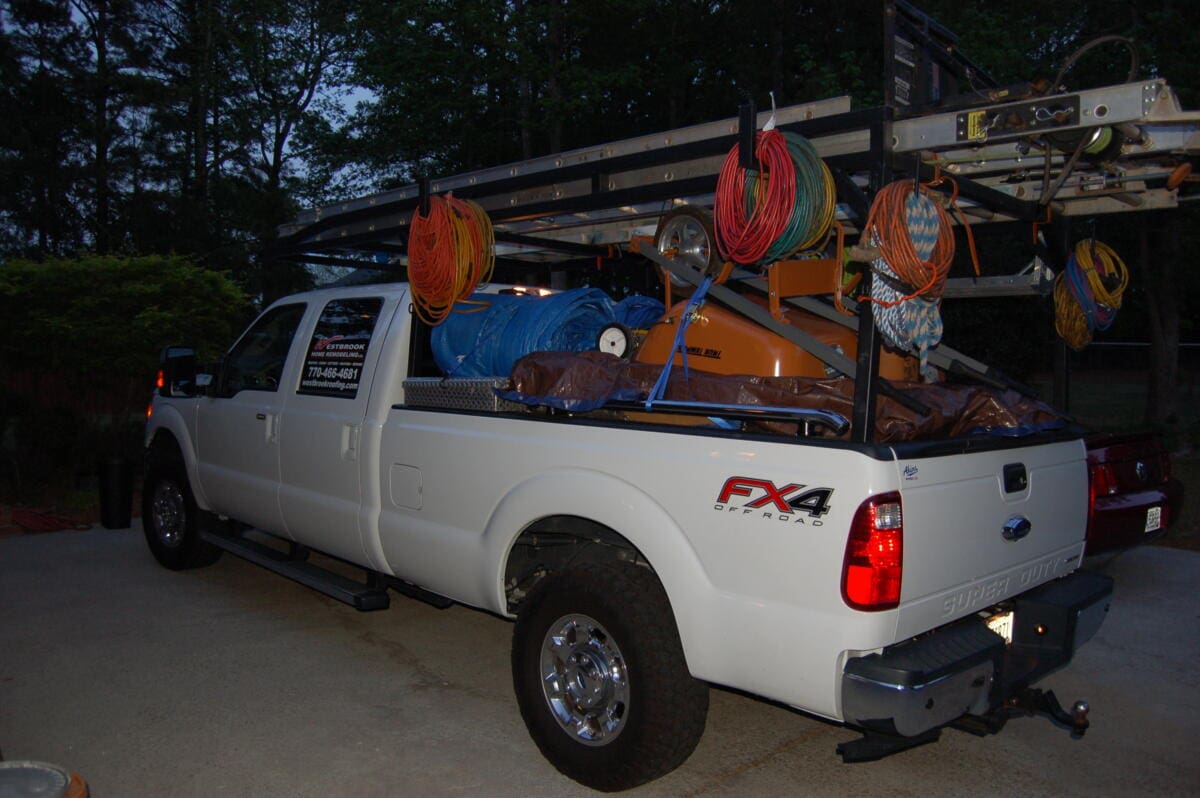 A white truck with several items in the back.