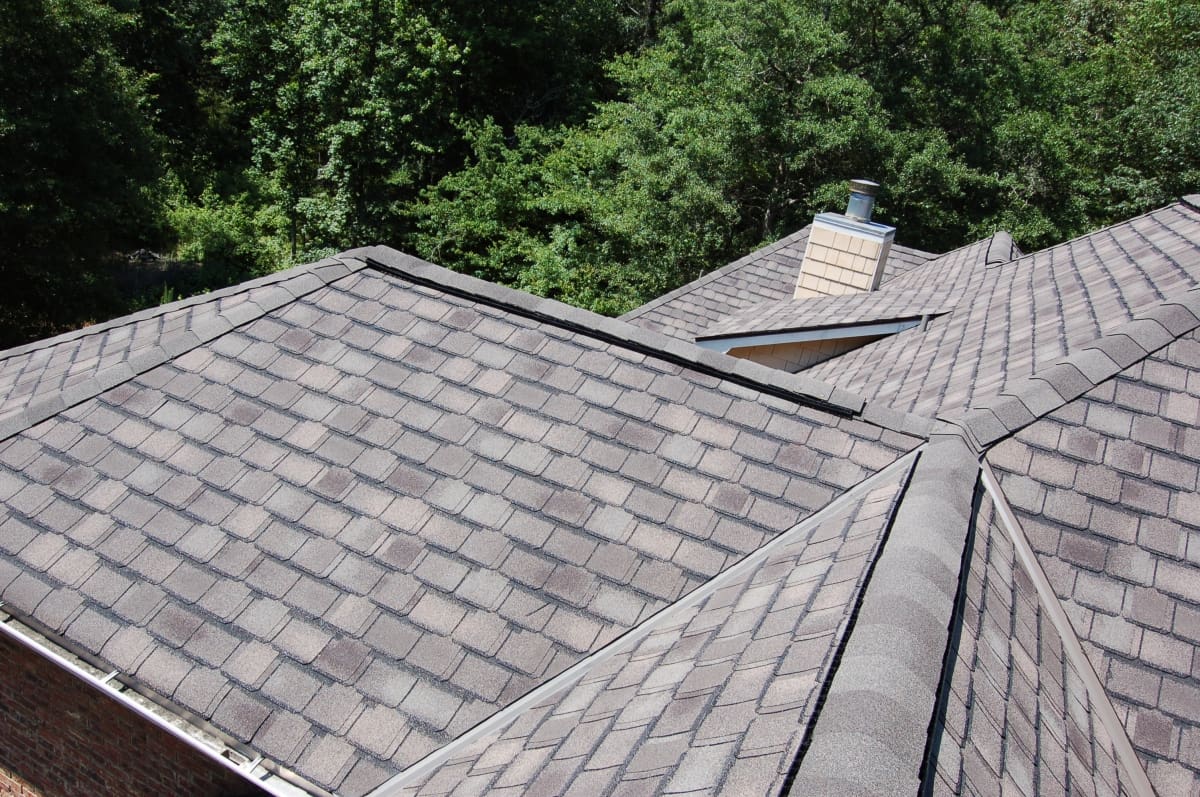 A roof with multiple shingles and a chimney.