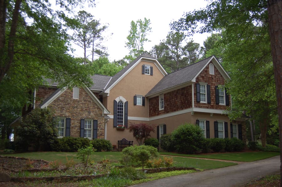 A large brick house with trees in the background.